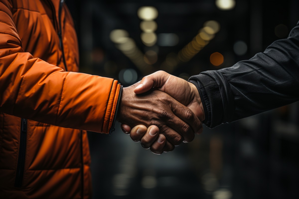 zu sehen: zwei Leute die sich die Hand geben