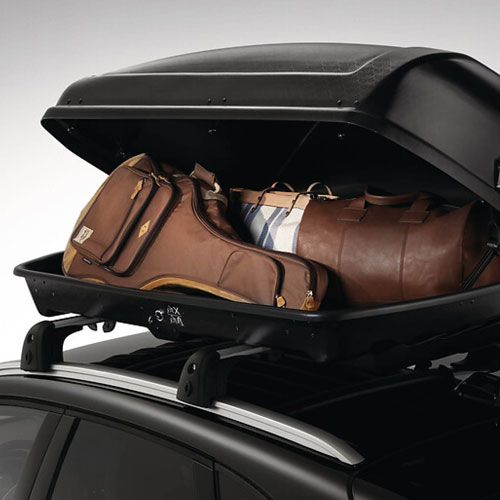 Zu sehen ist eine Dachbox, gefüllt mit einer Gitarre und Koffern. 